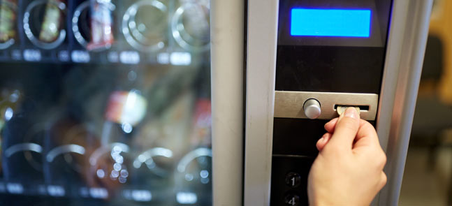 putting money in vending machine